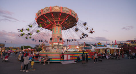People enjoying the rides at the Washington State Fair at sunset. The Fair is known by locals as the Puyallup fair and has been running since 1900.