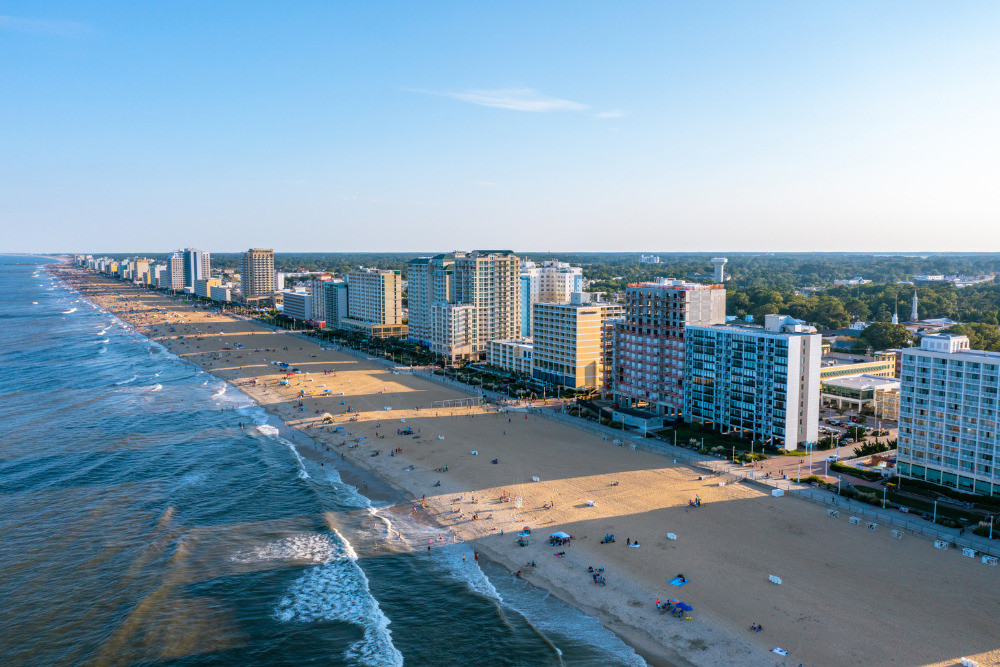 An aerial view of the Virginia Beach oceanfront as the sun sets. Virginia Beach is one of the best cities to live in Virginia.