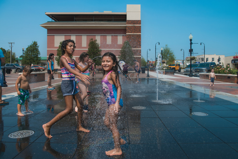 Children play in an interactive splash pad in the revitalized downtown Rose District in Broken Arrow, OK. 