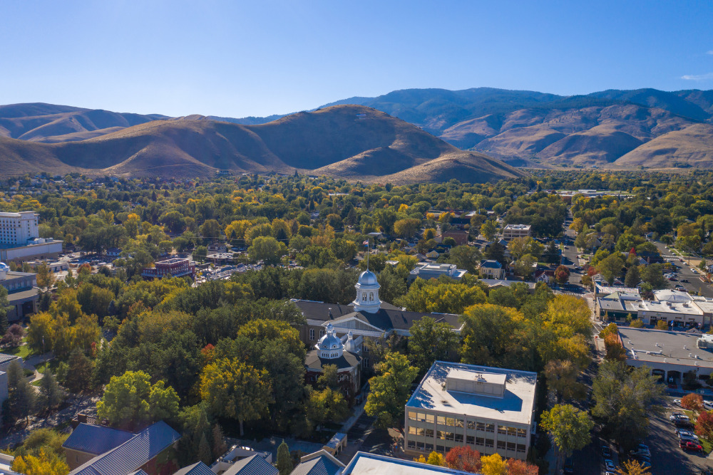 A view of Nevada's state capitol building and capitol mall area with the Sierra Nevada mountains in the background in Carson City NV.