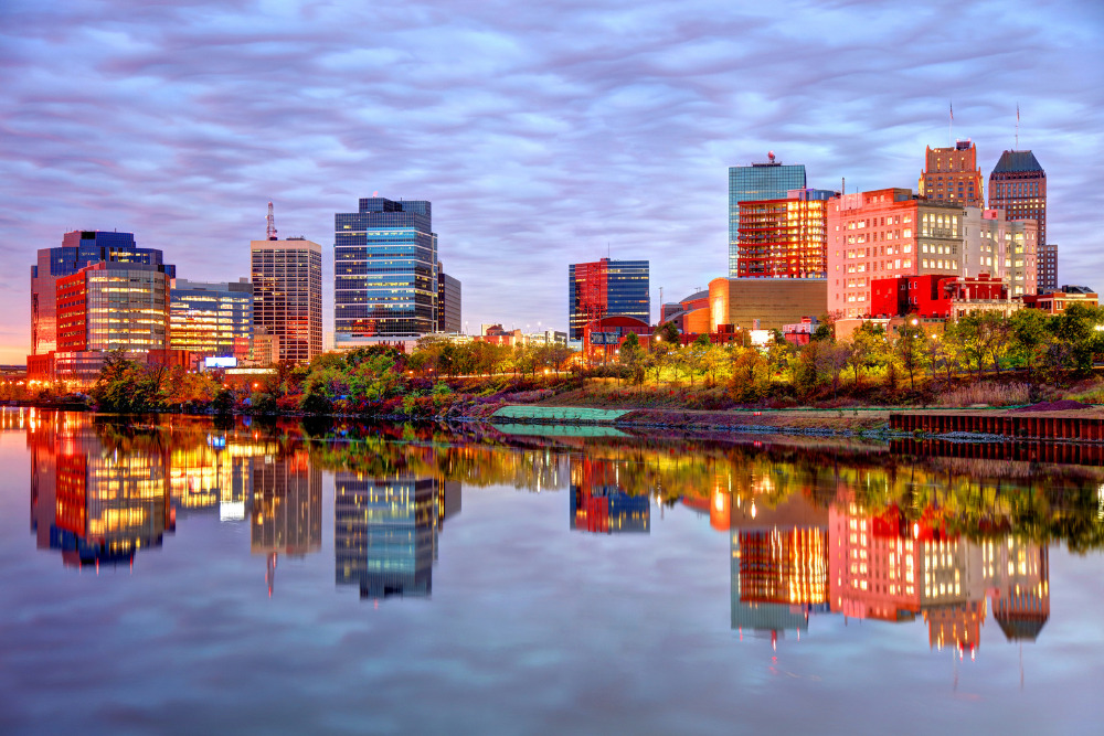 A colorful view of the Newark, New Jersey, skyline reflected in the water at sunset. Newark is a best place to live in New Jersey.