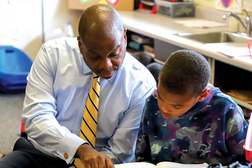 Superintendent Dr. Eric C. Bracy working with a student.
