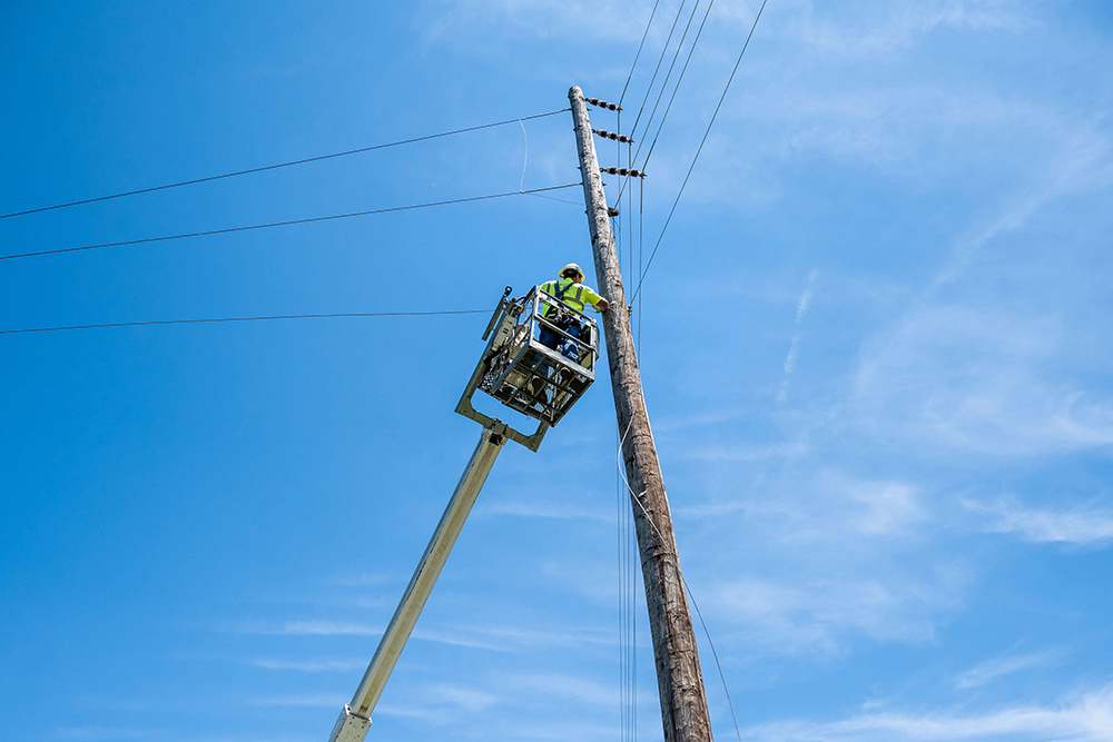 A Cumberland Connect employee works on phone lines from an elevated work platform.