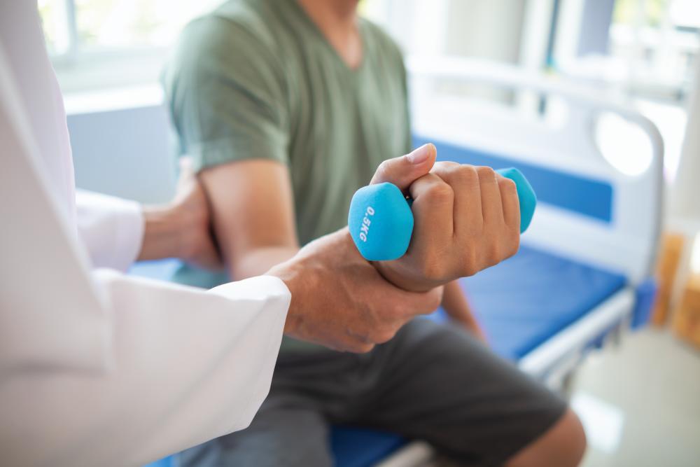 doctor is helping a patient move her muscles after recuperating from a muscle injury and wanting to rehabilitate her to be able to use her normal daily life with continuous physical therapy.