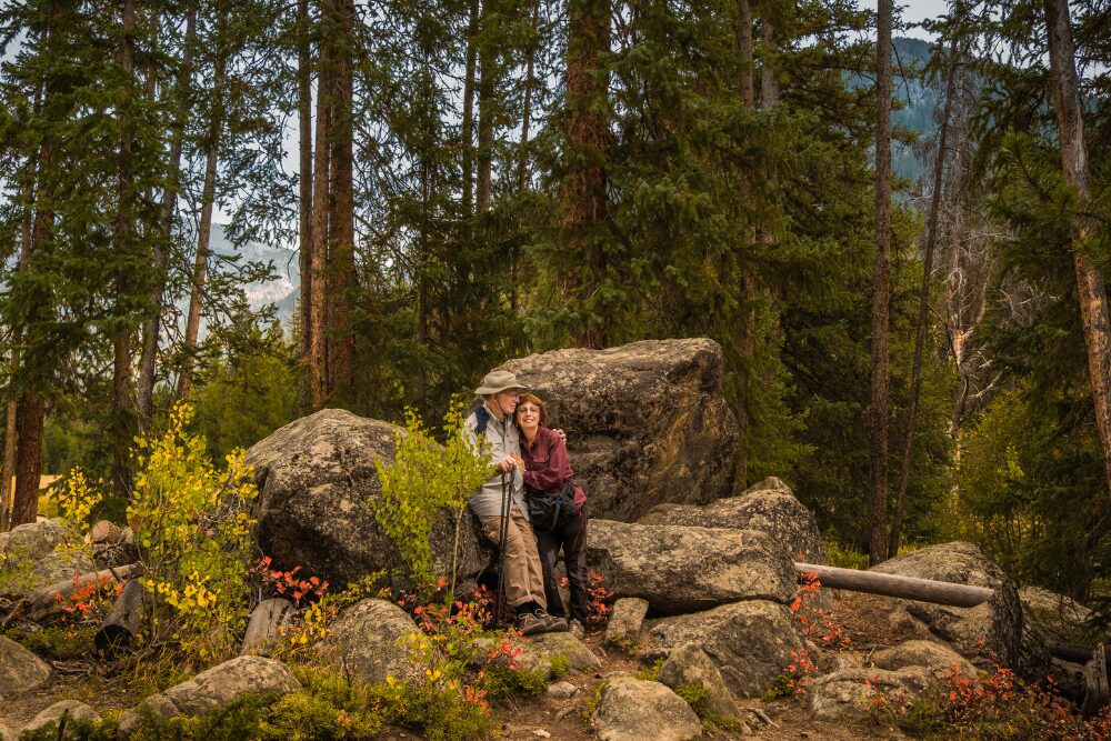 Environmental portrait of senior couple in Rocky Mountains, Colorado, in autumn. Colorado is one of the best states for retirees.