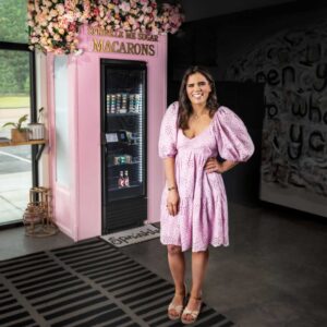 Raina Schultz of Sprinkle Me Sugar stands in front of her macaron vending machine at Catbird Studio in Jackson, Tennessee.