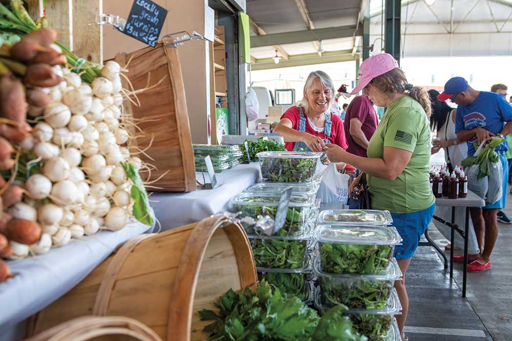 Cheres Pennington sells produce to Stephanie Johnson at her Rosecreek Farms boot at the West Tennessee Farmers Market in the Jackson Walk are near downtown Jackson.