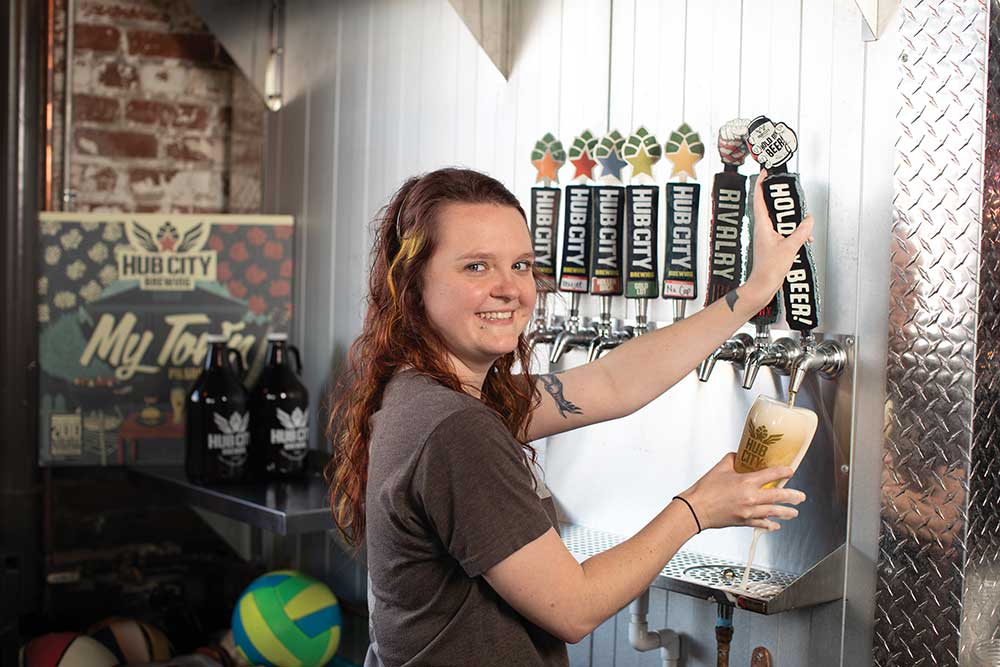 Woman pours beer from the tap at Hub City Brewery in Jackson, TN.