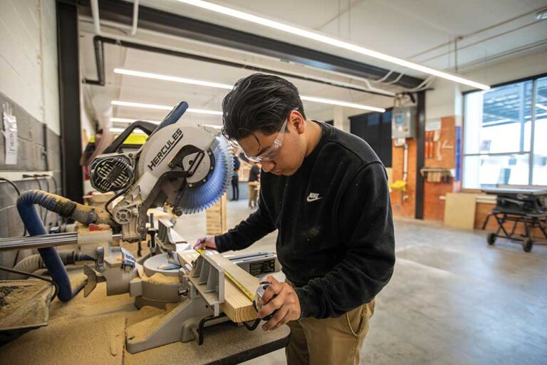 Construction Career Center student Eddie Lucas makes a cut on a miter saw at the school in Chattanooga. ©Journal Communications/Nathan Lambrecht