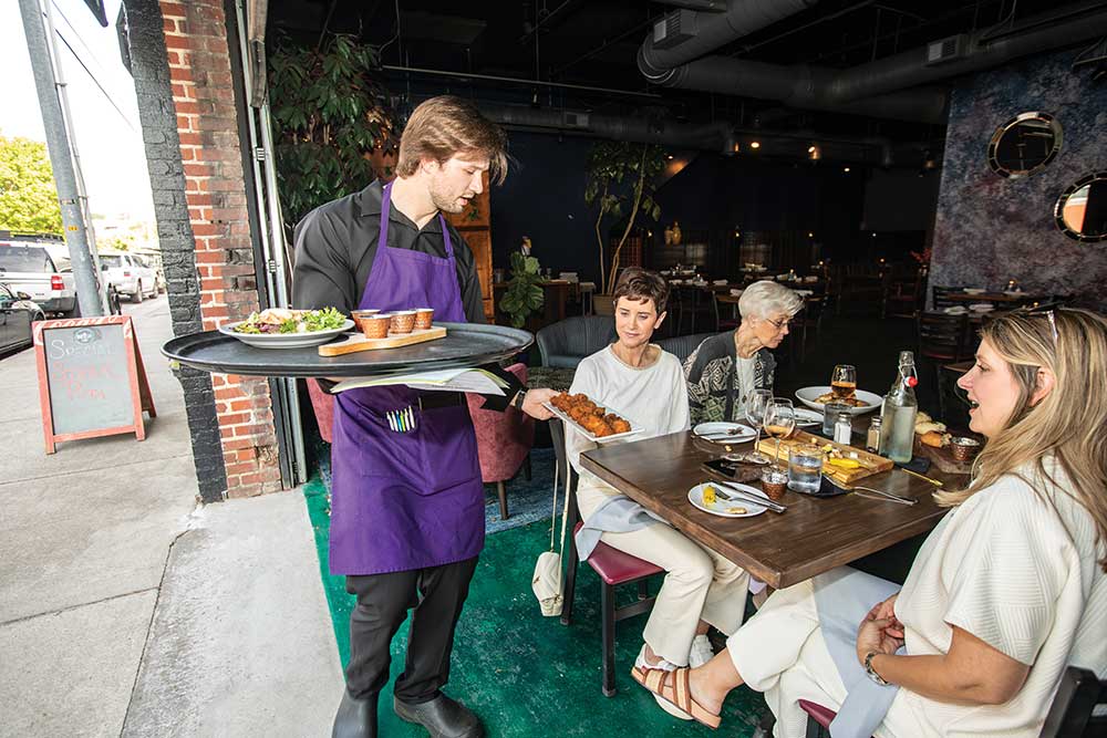 Collin Hubbard servers the Duncan family at Indigo Cafe in Cleveland. ©Journal Communications/Nathan Lambrecht
