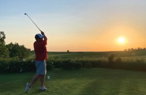 Man swings his golf club at dusk at Collison Par 3 Golf Course, which is located in Marshalltown, IA.