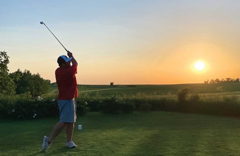 Man swings his golf club at dusk at Collison Par 3 Golf Course, which is located in Marshalltown, IA.