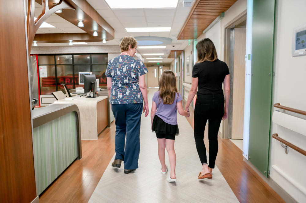 Patient with nurse and parent in the pediatric care unit.