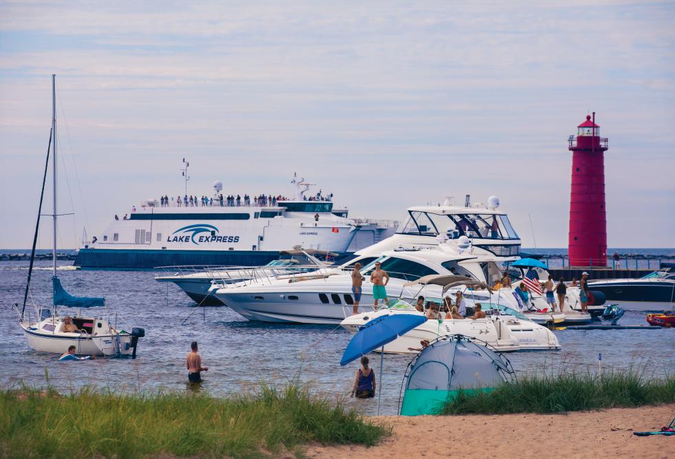 Boaters gather in the harbor, under the protection of the breakwater barrier at Pere Marquette Park in Muskegon, Michigan.