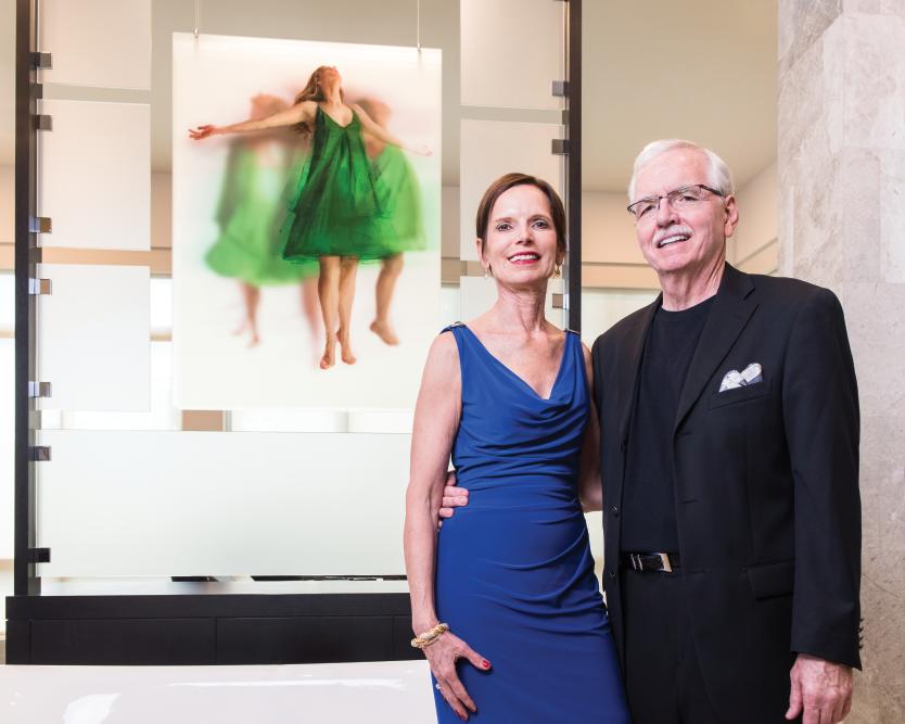 Dr. Elaine Melotti Schmidt and Steven Alan Bennett in front of a work by artist Michelle Jader.