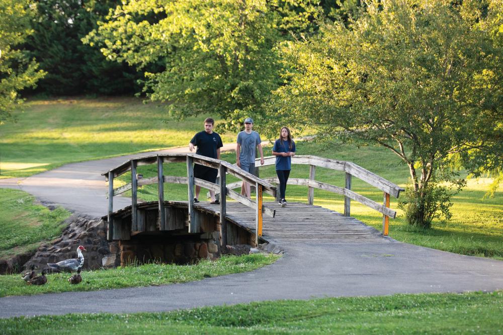 Visitors stroll across a walking bridge along the Maryville-Alcoa greenway at Bicentennnial Greenbelt Park in downtown Maryville, TN.