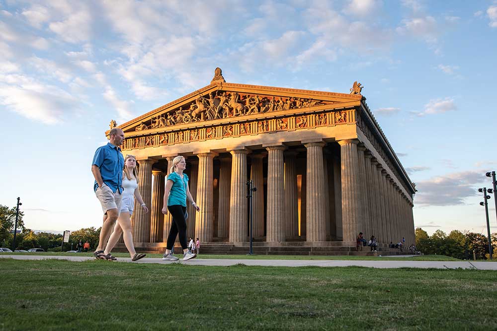 People pass by The Parthenon while on the hike and bike trail at Centennial Park in Nashville.