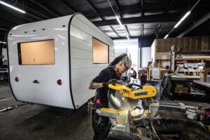 Keunarene Benitez cuts a piece of interior trim for a mobile business trailer at Aero Build in Nashville.