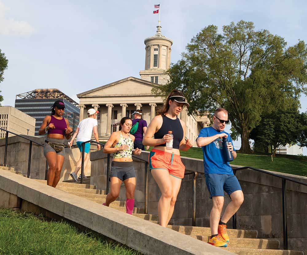 Participants in the Capitol Steps Workout run down a set of steps on the grounds of the Tennessee State Capitol in Nashville.