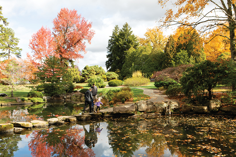 People guide their children over a rock bridge at the Japanese Garden at the Dawes Arboretum in Newark, OH.