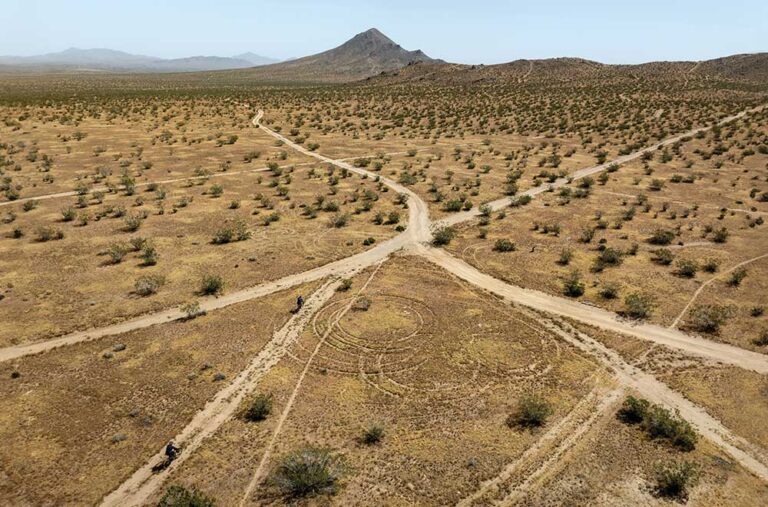 Mountain bikers ride the rocky trails at Bell Mountain in Apple Valley, California. Drone photo.