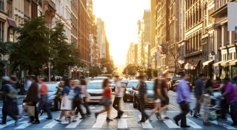 Crowds of people walking across a busy crosswalk at the intersection of 23rd Street and 5th Avenue in Manhattan New York City
