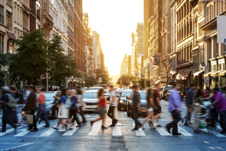 Crowds of people walking across a busy crosswalk at the intersection of 23rd Street and 5th Avenue in Manhattan New York City
