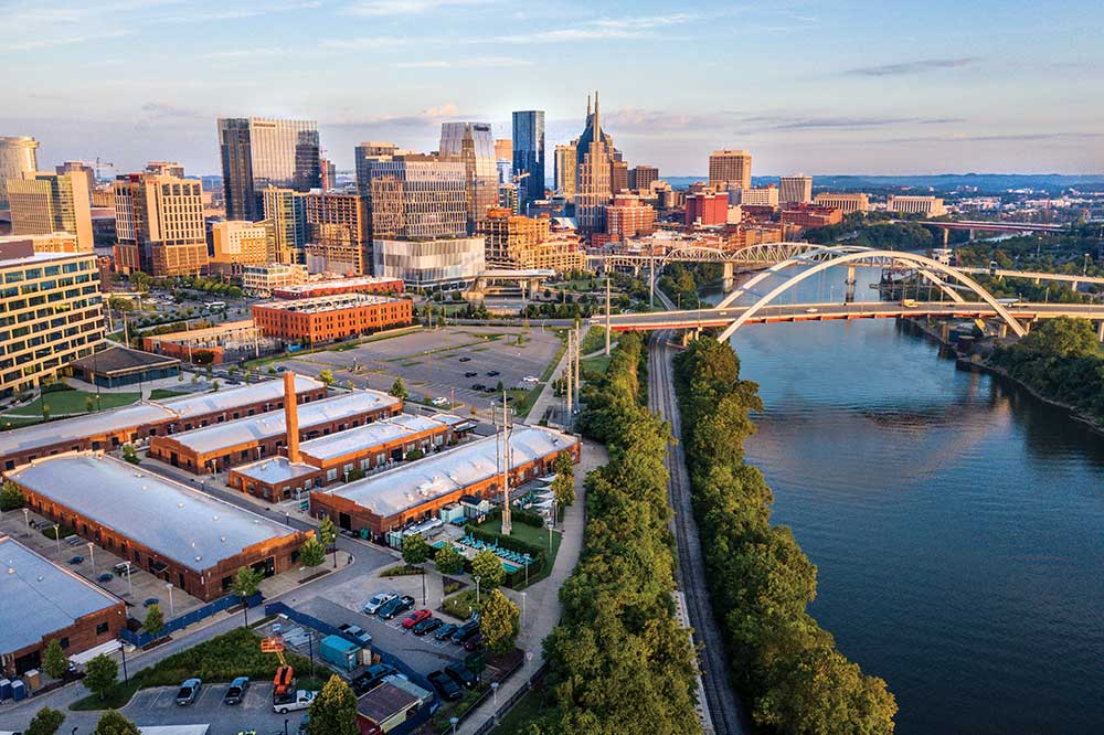 The Shelby Street Bridge, crossing the Cumberland River, and the downtown skyline at sunrise in Nashville, Tennessee.