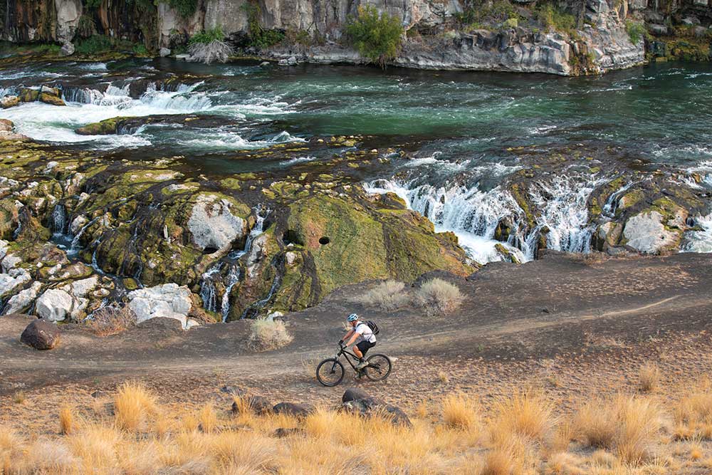 Andrew Perttula, owner of Pertt's Bike Rental, rides a mountain bike at Auger Falls in the Snake River Canyon, in Twin Falls, Idaho.