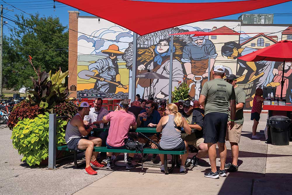 People around a table at a brewery in Kickstand-The District: Czech Village & New Bohemia-Cedar Rapids.