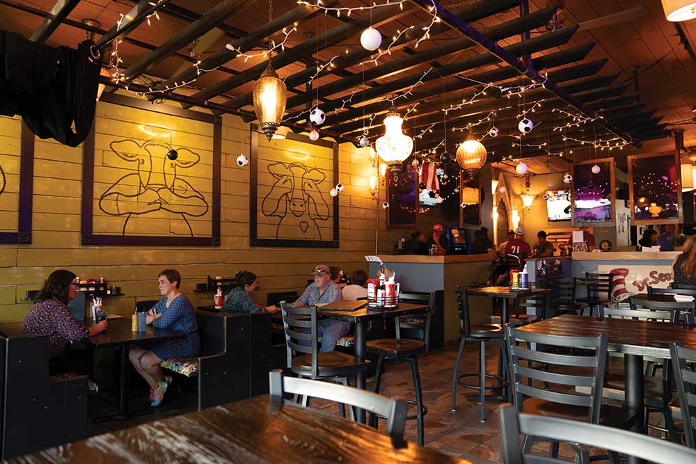 People enjoying food and drinks at the Sacred Cow Tavern in Cedar Rapids, Iowa.
