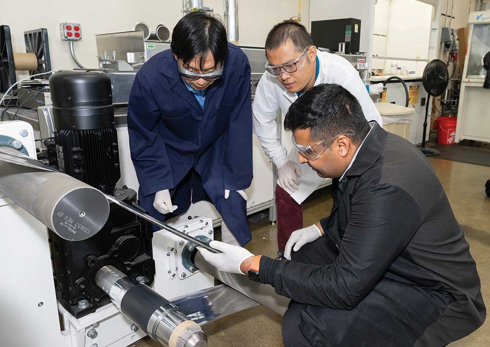 ORNL scientist Zhijia Du, white coat; former ORNL scientist Jianlin Li, blue coat; and Ateios CEO Rajan Kumar inspect battery components during a pilot production run. Ateios is a Cohort 2022 company. Credit: Kurt Weiss/ORNL, U.S. Dept. of Energy