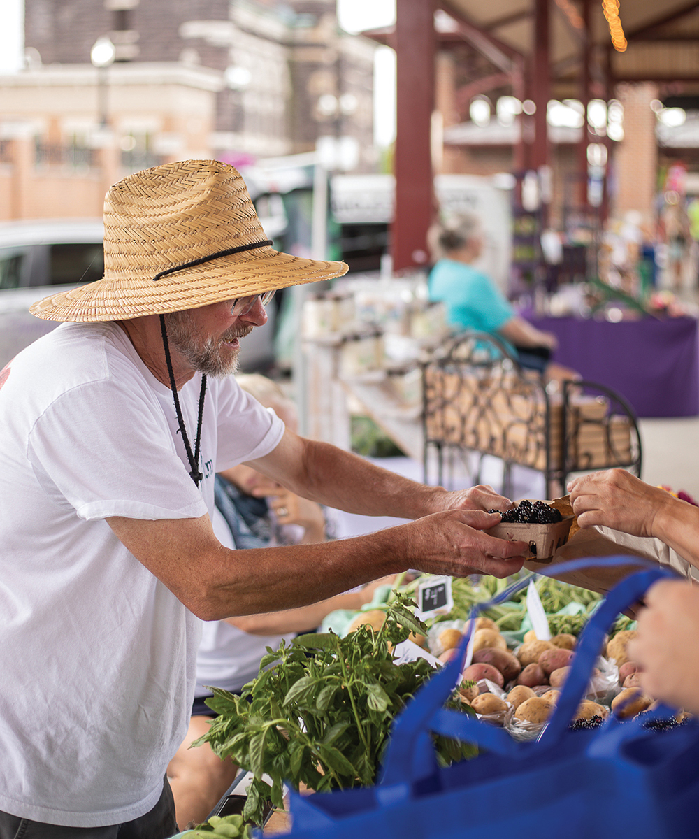A customer purchases blackberries at Canal Market District Farmers Market in Newark, OH.