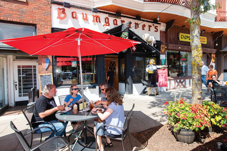 Diners eat lunch at outdoor tables in front of Baumgartner's Cheese Store & Tavern on the Courthouse Square in downtown Monroe, WI.