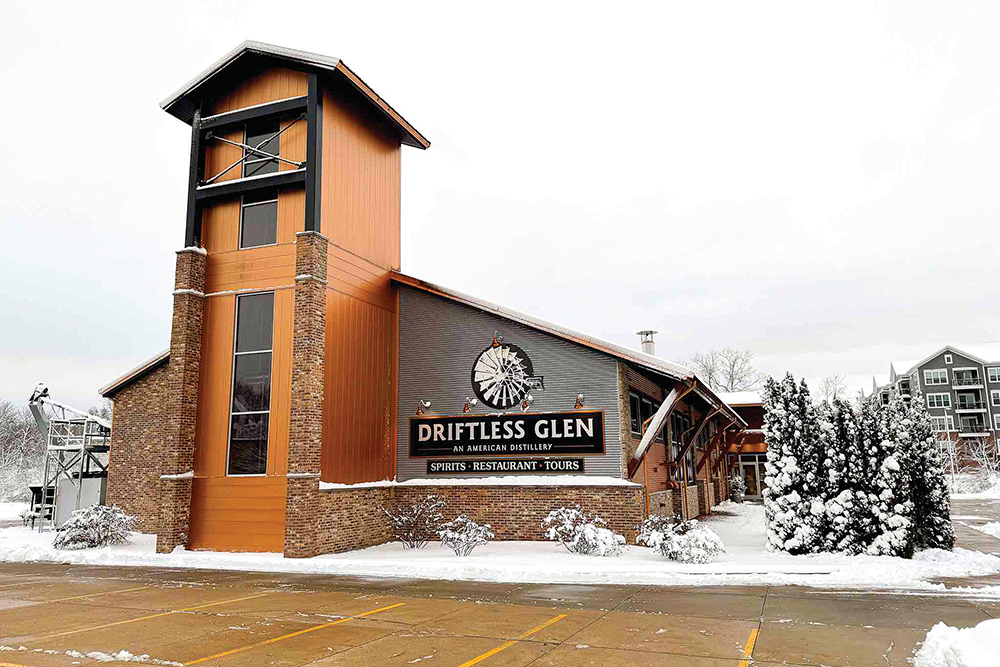 Driftless Glen Distillery in Baraboo, WI, is shown in winter, surrounded by snow.