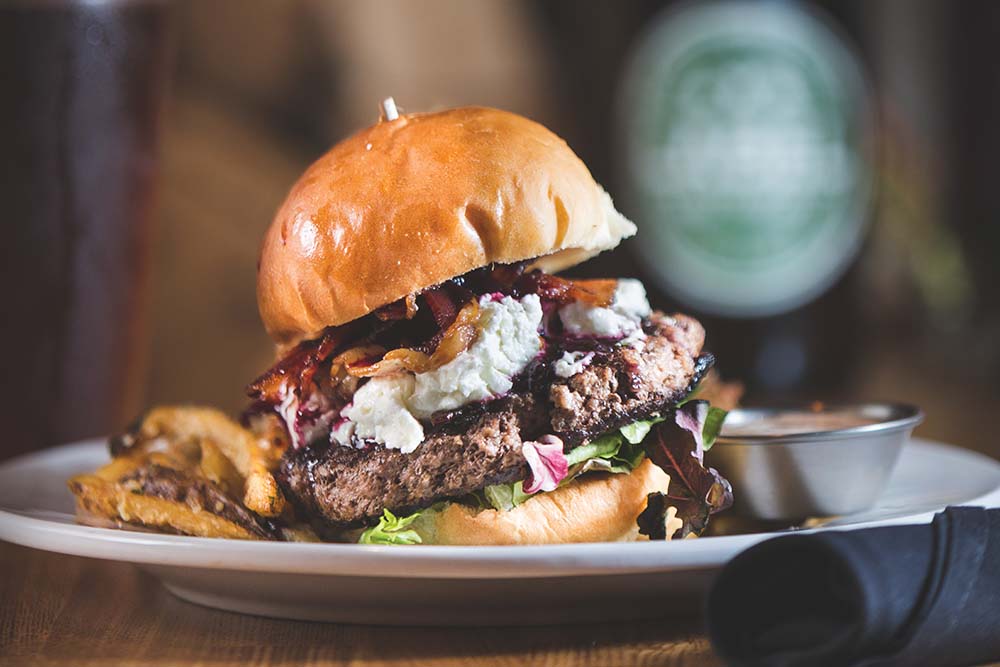 A gourmet burger piled high with toppings at Label Restaurant in Johnson City, TN.