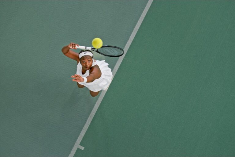 Overhead view of female tennis player playing match in tennis court.