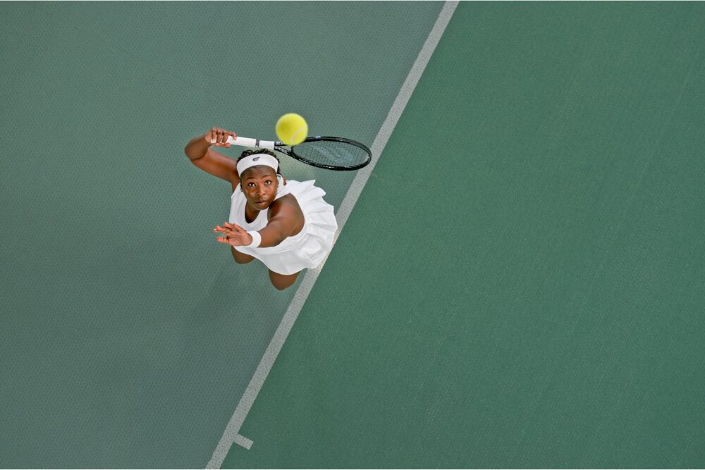 Overhead view of female tennis player playing match in tennis court.