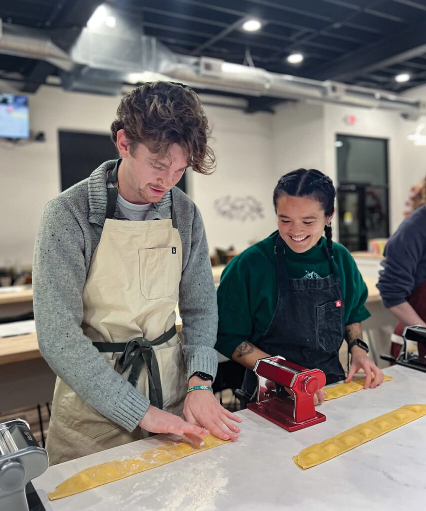 Young adults make pasta during a cooking at The Recipe in downtown Ames, IA.