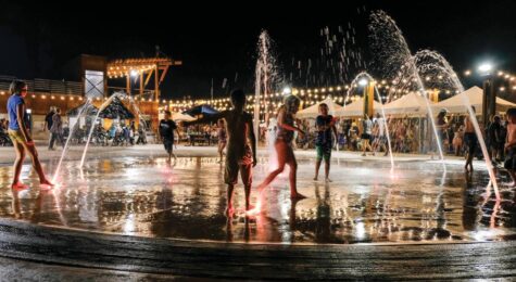 Children play in a water fountain at the 5150 Festival