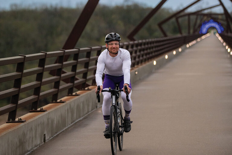 A cyclist rides across The High Trestle Trail Bridge in Madrid, Iowa. The bridge crosses the Des Moines River.