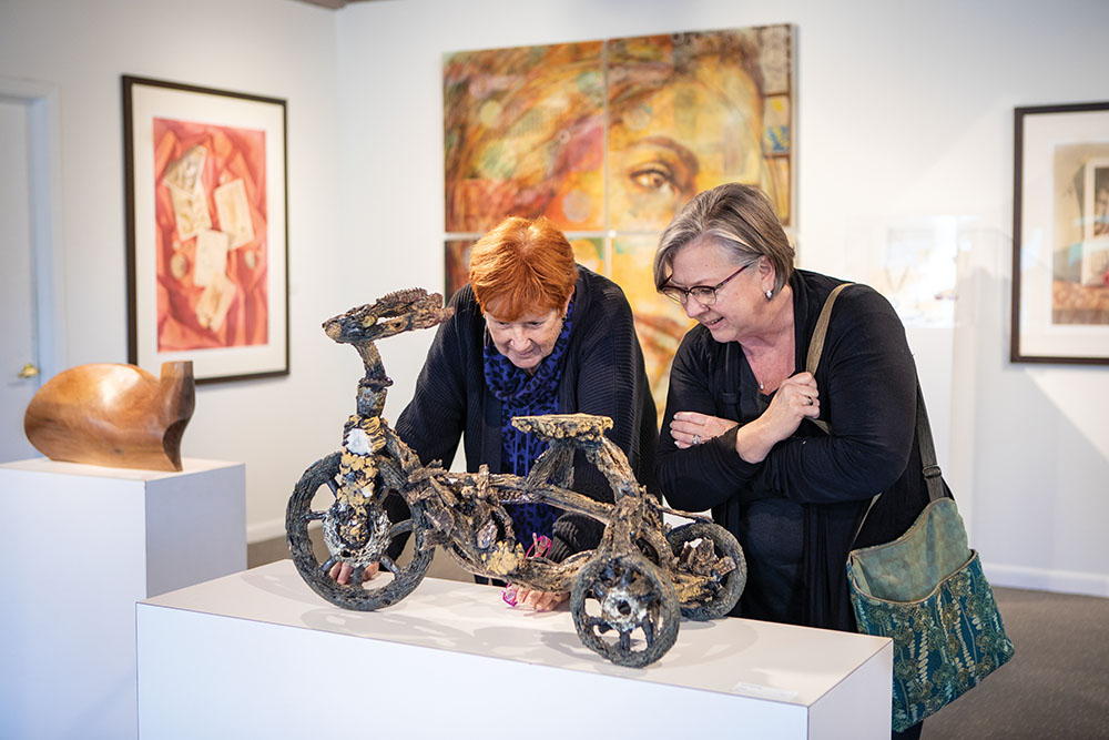 Kathy O’Meara, left, and Fran Gardner look at a sculpture from a Florida artist at the Atlantic Center for the Arts’ Arts on Douglas gallery in New Smyrna Beach., FL