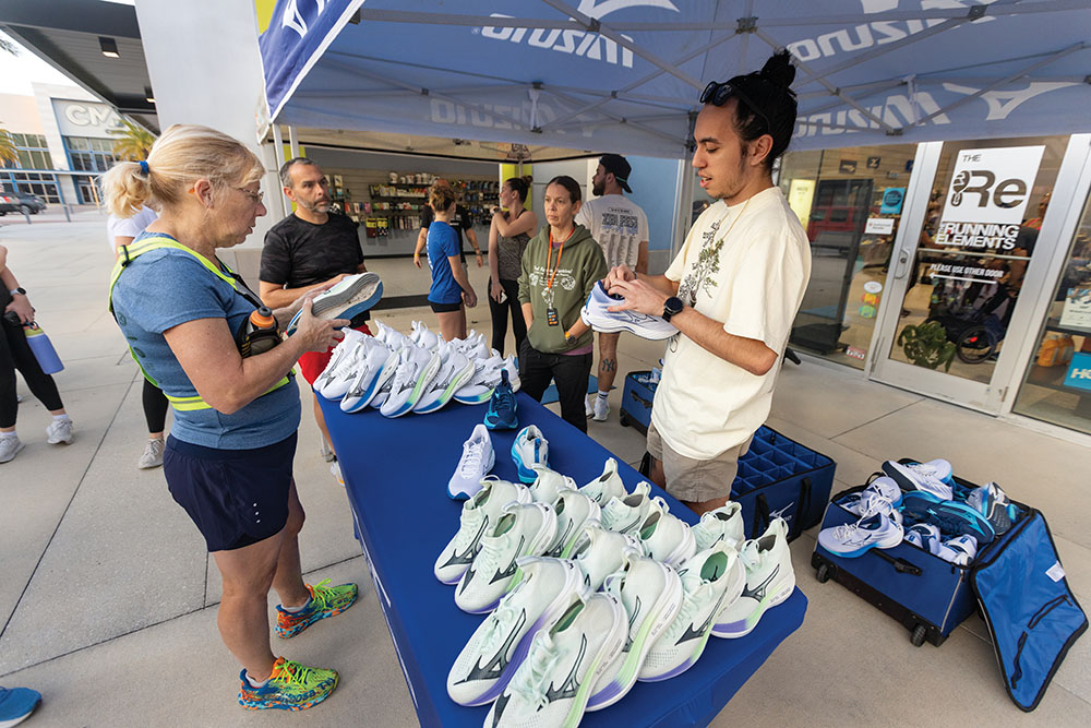 A representative from Mizuno shoes lets The Running Elements' Run Club members try out shoes at the store before the Wednesday evening run in Daytona Beach, Florida.