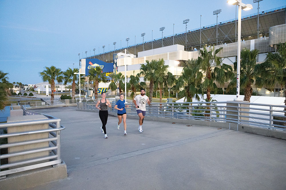 The Running Elements' Run Club members run past the Daytona International Speedway during the Wednesday evening run in Daytona Beach, Florida.