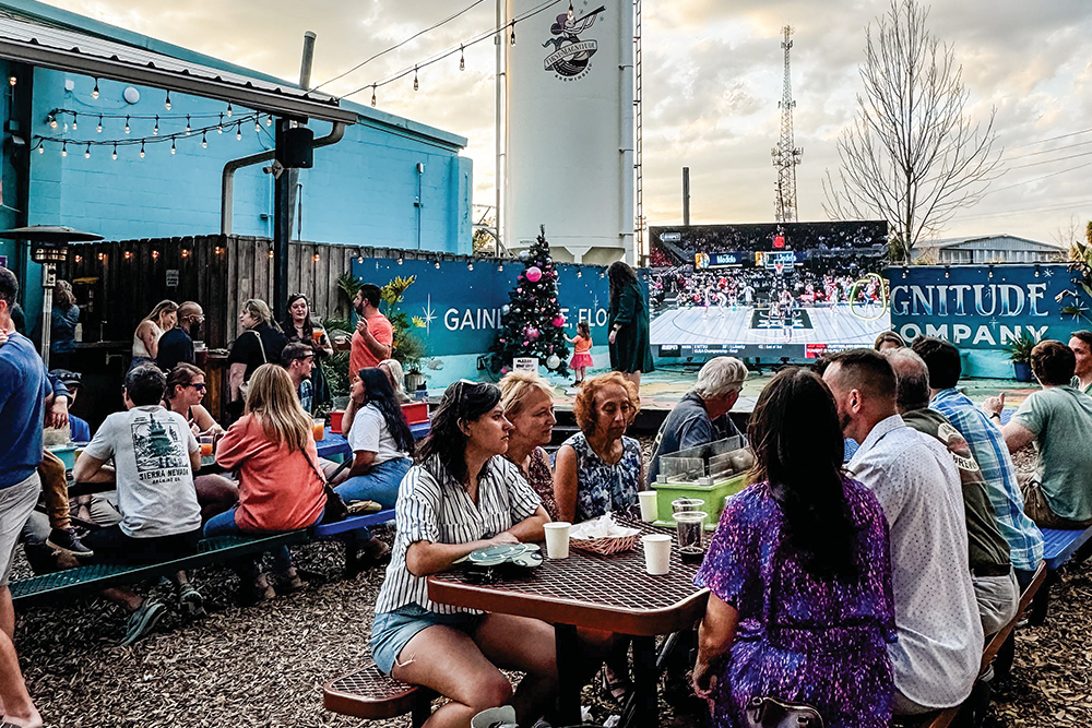 People enjoy beers at outdoor tables at First Magnitude Brewing Co.