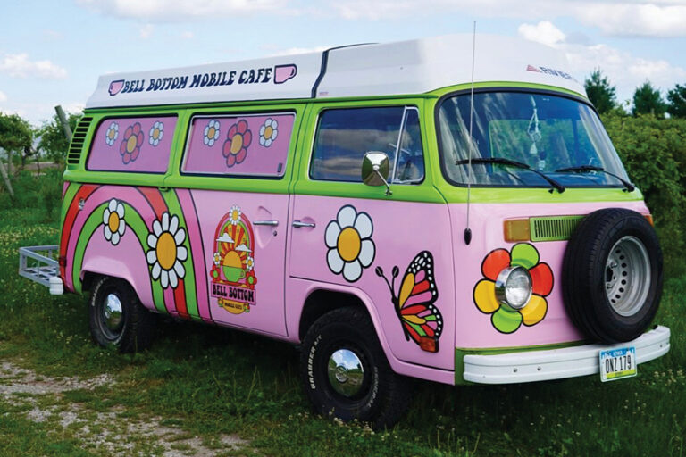 A pink 1978 VW Riviera bus painted with rainbows, butterflies and flowers is the home of Bellbottom Cafe, which serves artisan coffees and teas in Ames, Iowa.