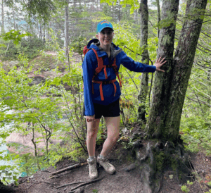 Jamie Van Buren poses next to a tree for a photo while hiking in Michigan's Upper Peninsula.