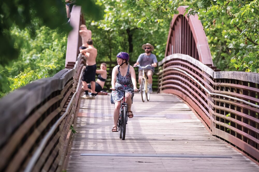 Cyclists ride across a wooden bridge over the West Fork Stones River on the greenway trail in Murfreesboro, Tennessee.