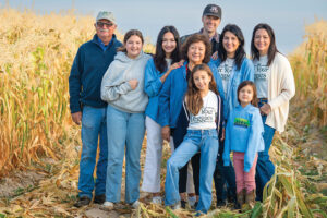 Several generations of the Wissel family, who have owned and run Wissel Farms since 1911, pose for a photo in a corn field.