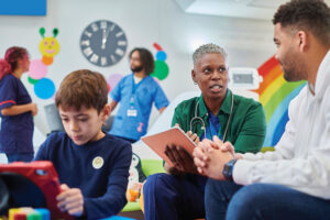 doctor with parent in children's hospital reception discussing medicine